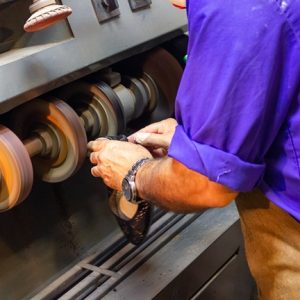 Traditional shoemaking, putting wax on the heel cap of a woman's
